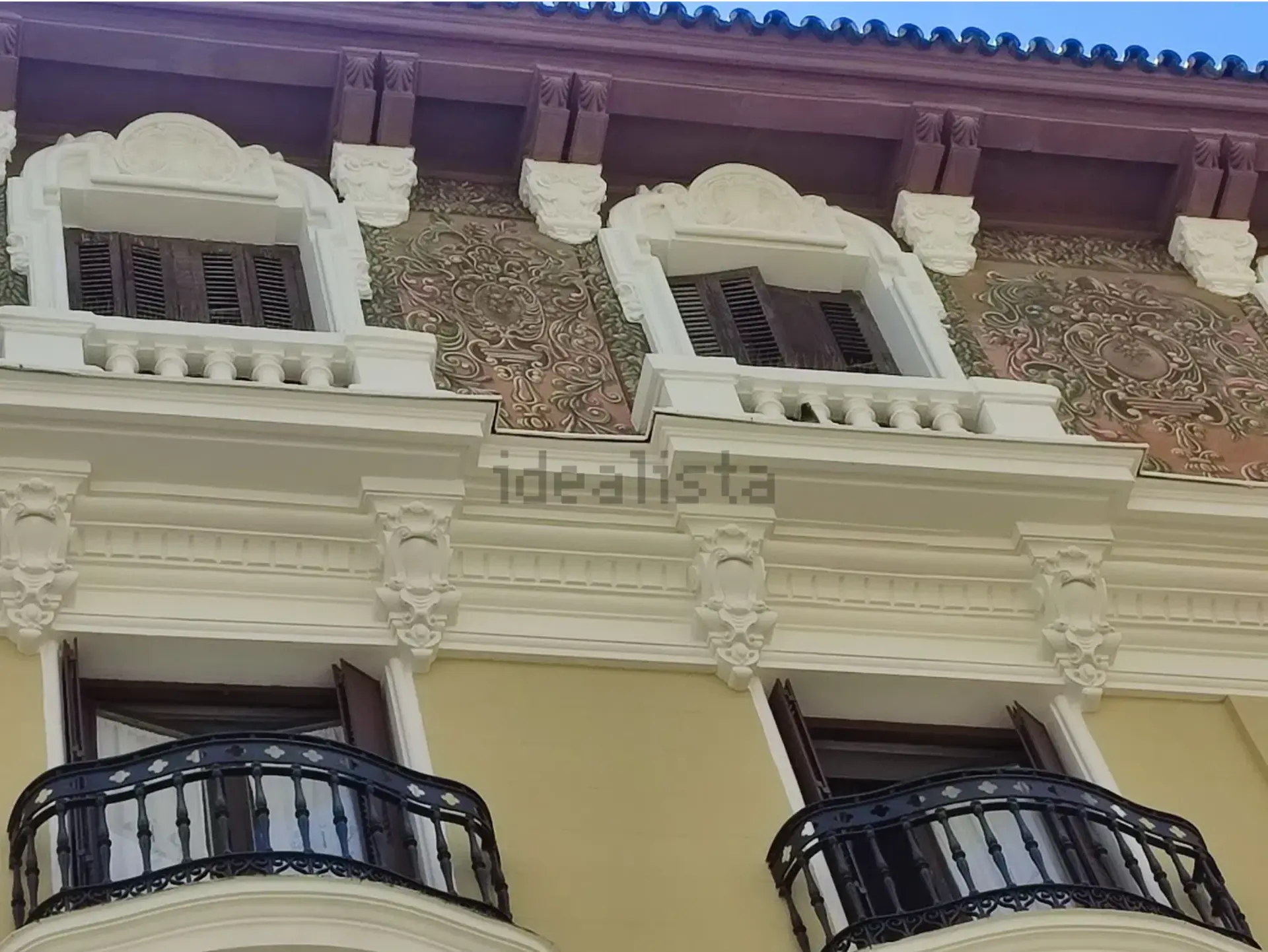 Fachada de la casa-palacio con balcones curvos y ornamentación neoclásica, Madrid