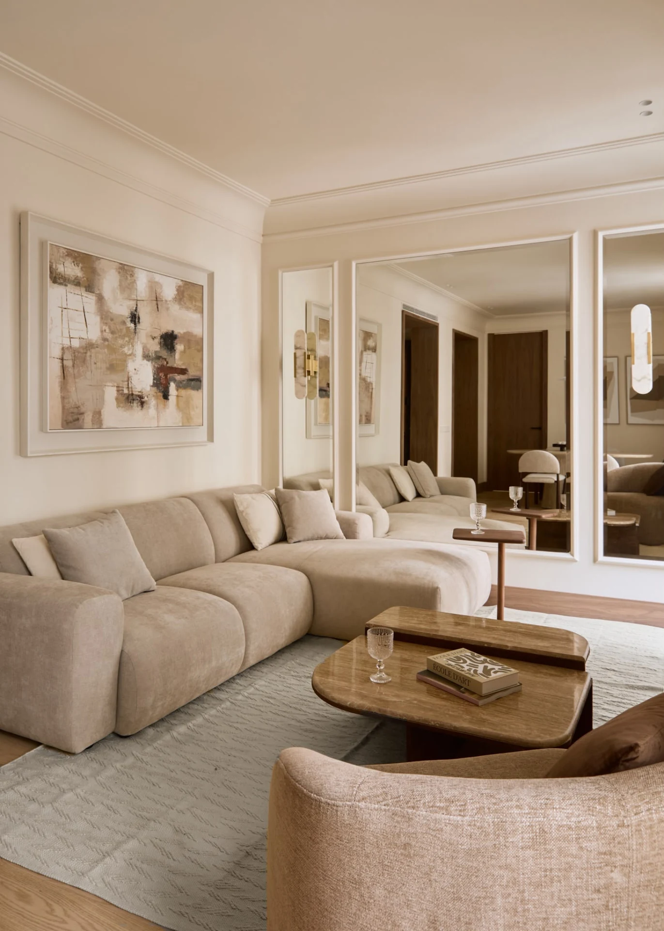 Living room with a light-coloured sofa and wall mirrors
