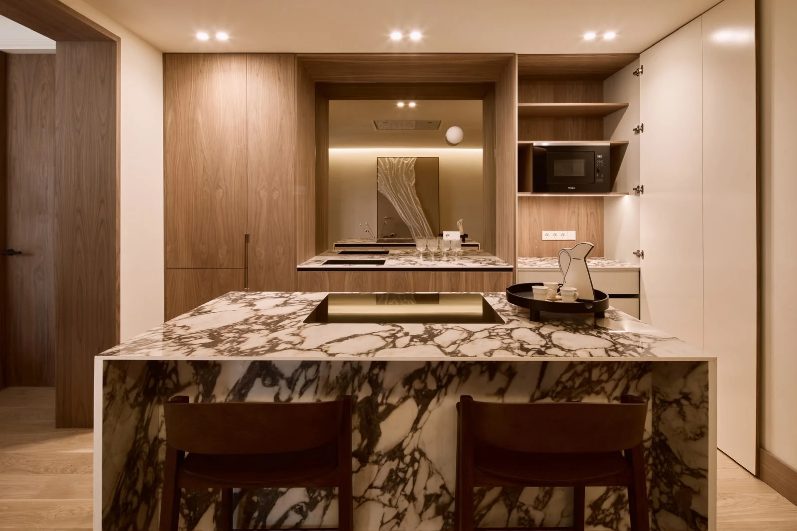 Porcelain island and open-plan kitchen with walnut cabinetry