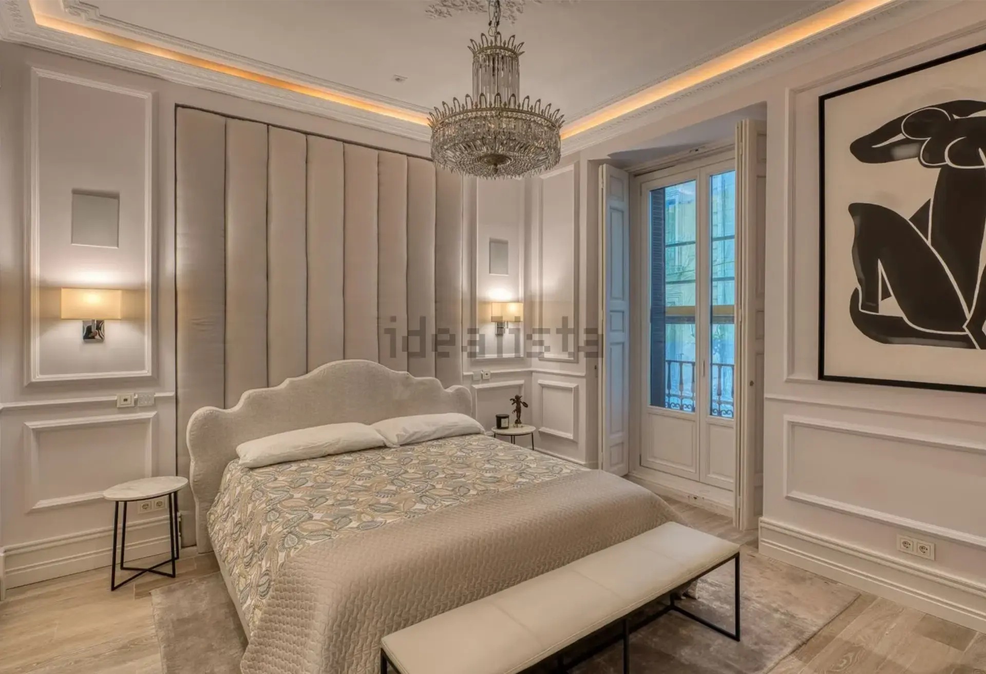 Dormitorio principal en suite con cabecero tapizado y candelabro