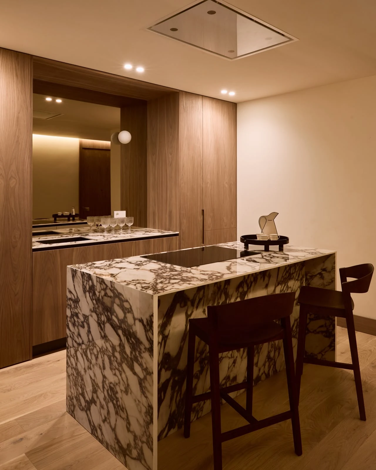 Open-plan kitchen with a Calacatta Viola porcelain island and walnut cabinetry