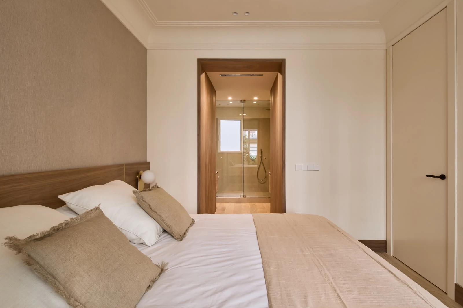 Bedroom with double bed, wooden headboard and bathroom access