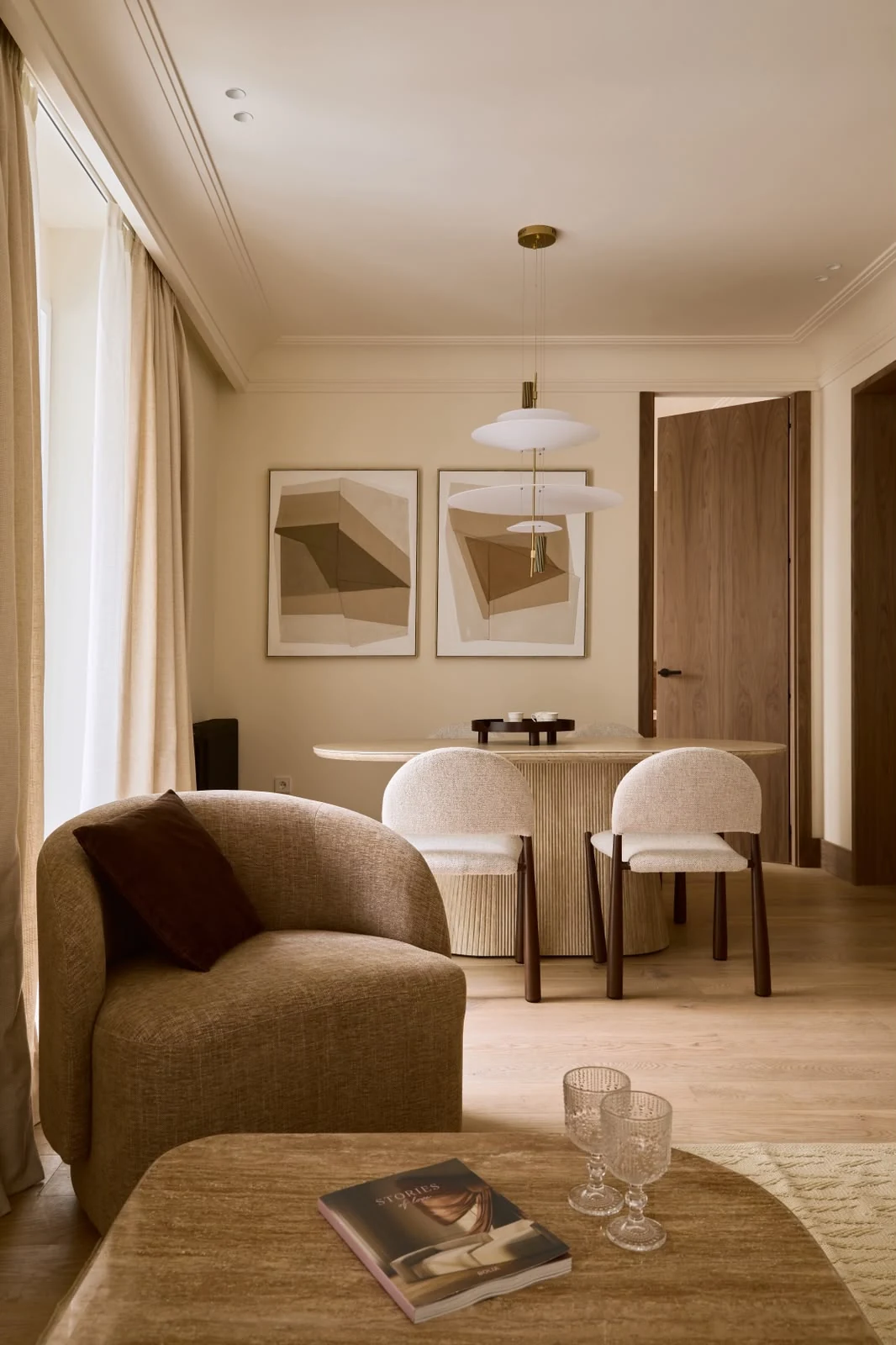 Dining area with an armchair by the window and framed artwork