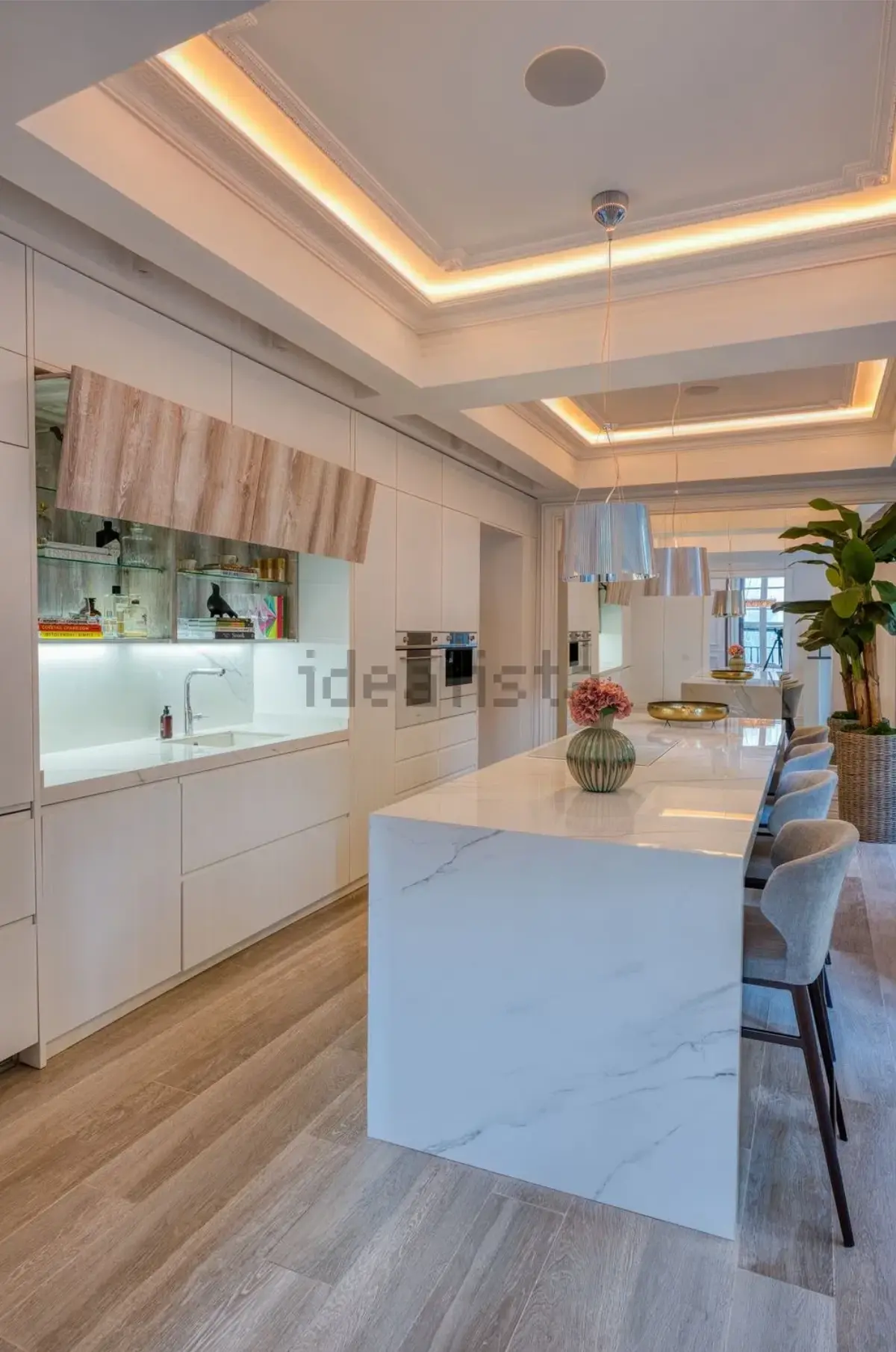 Vista longitudinal de la cocina con mobiliario blanco