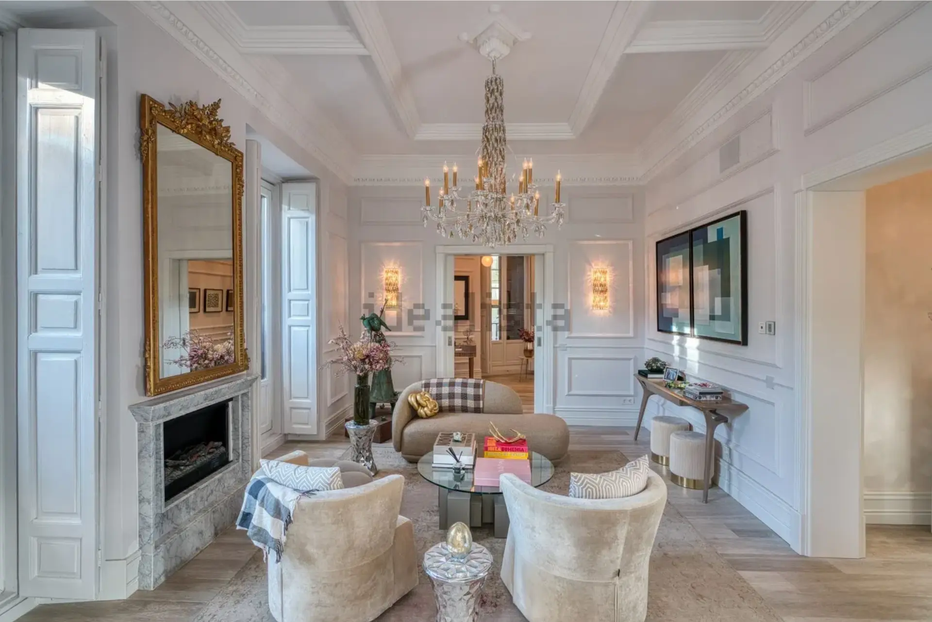 Salón en esquina con molduras, chimenea y espejo dorado en la casa-palacio