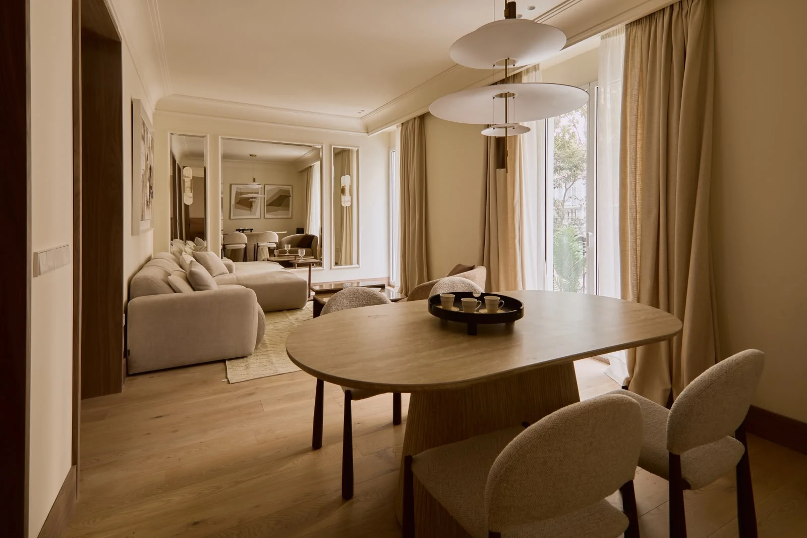 Dining table and living room with two street-facing balconies