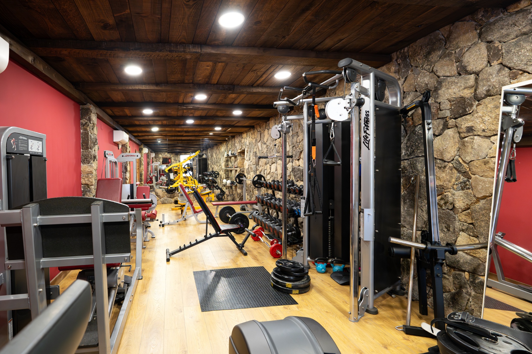 Gimnasio privado con muros de piedra natural
